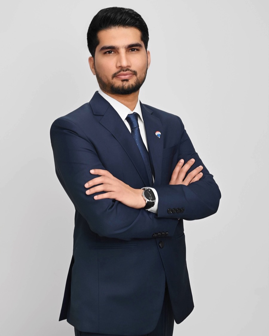 Sharry Minhas, RE/MAX Bozz Realty agent in Surrey, photographed in a navy suit